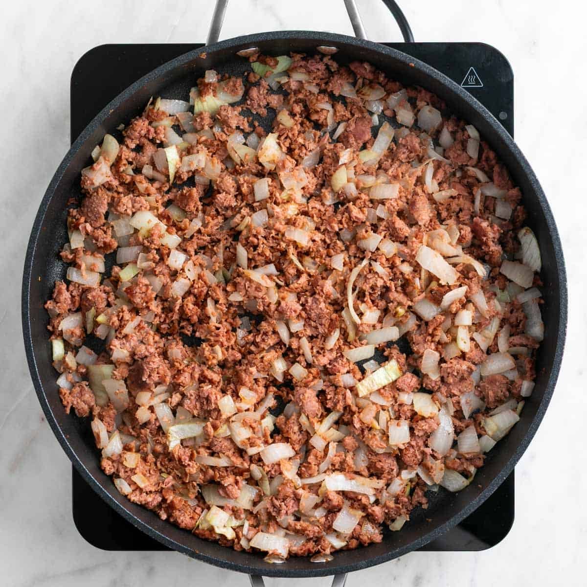 Cooked vegan sausage in a skillet.