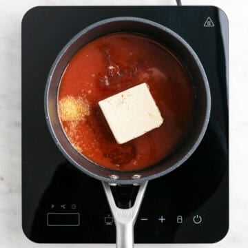 Ingredients for vegan buffalo sauce in a saucepan.