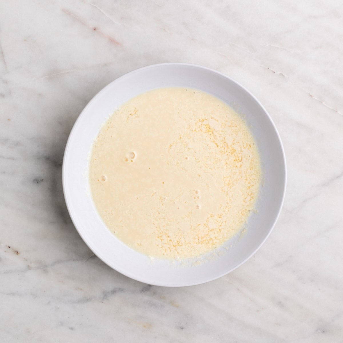 Shallow dish with vegan buttermilk for breading.