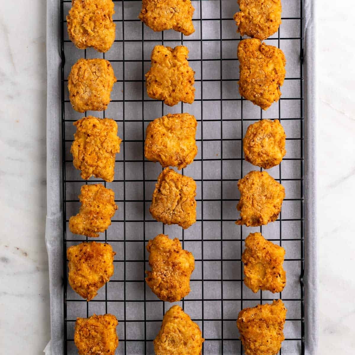 Fried tofu resting on a wire rack.