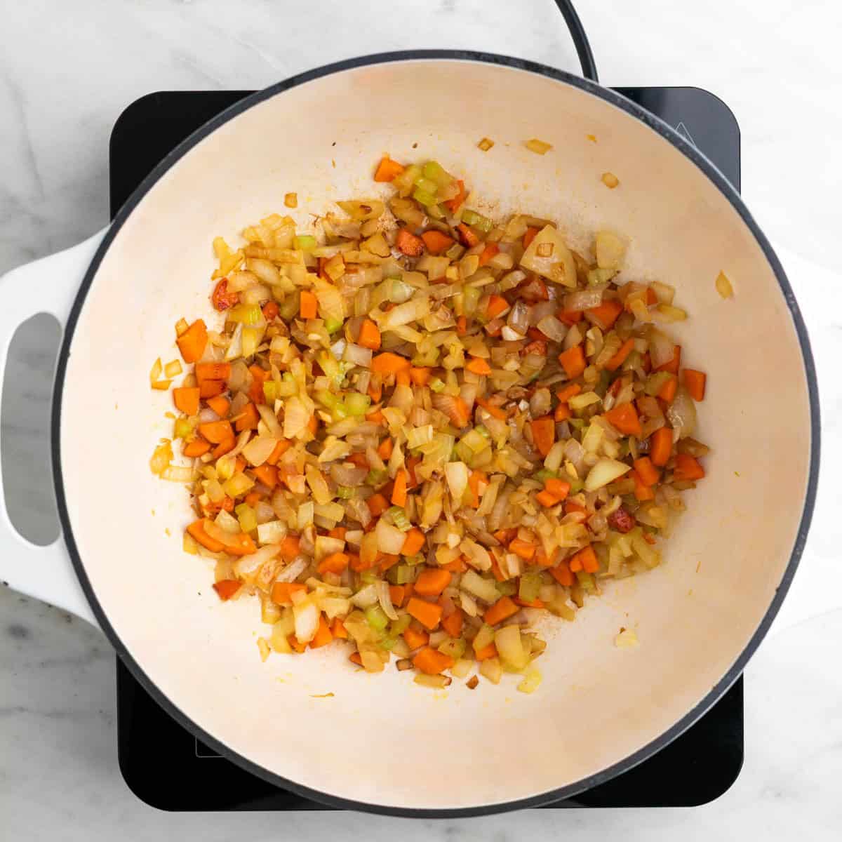 Onion, celery, carrot, and garlic sautéed in a large pot.