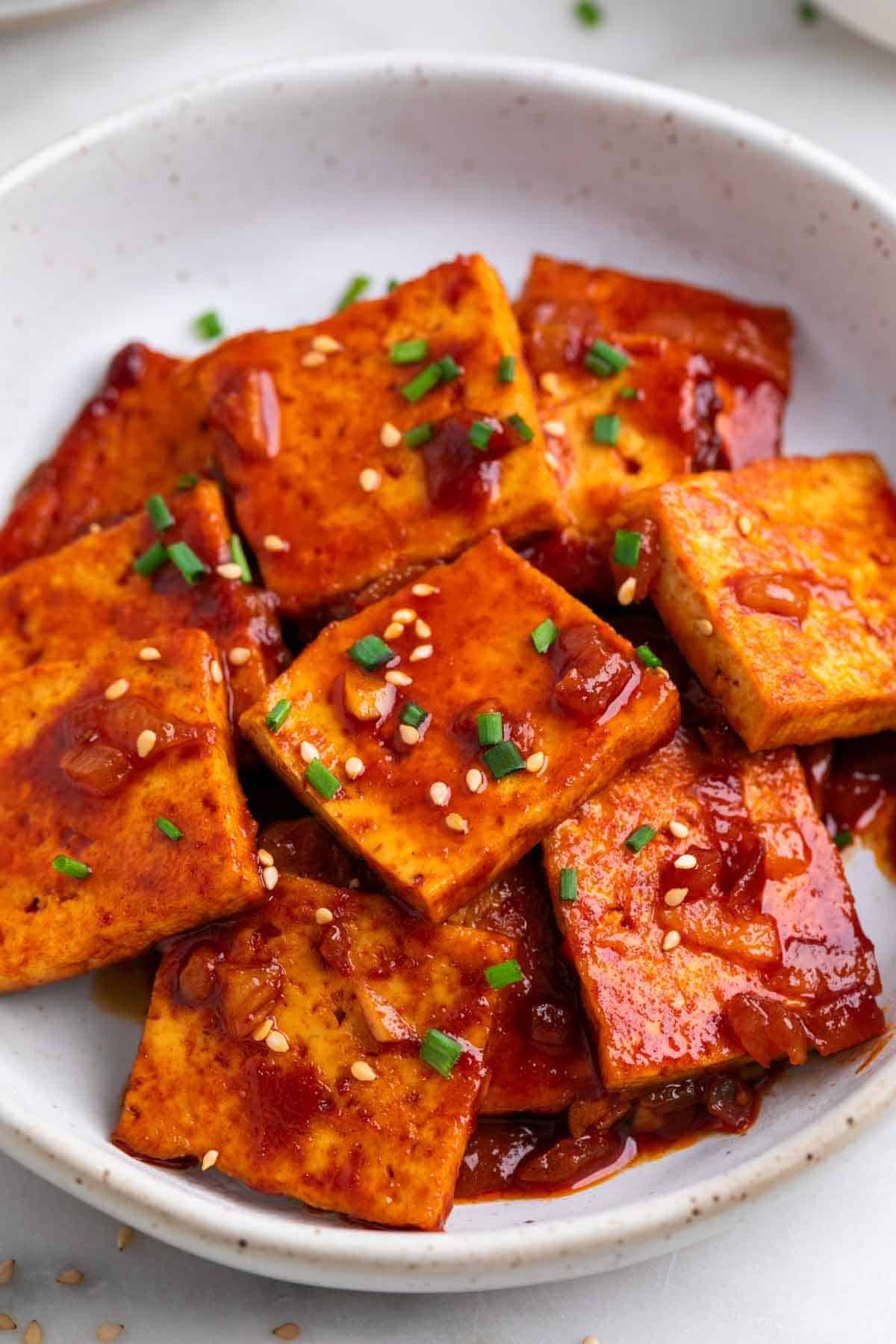 Spicy tofu garnished with sesame seeds and chives.