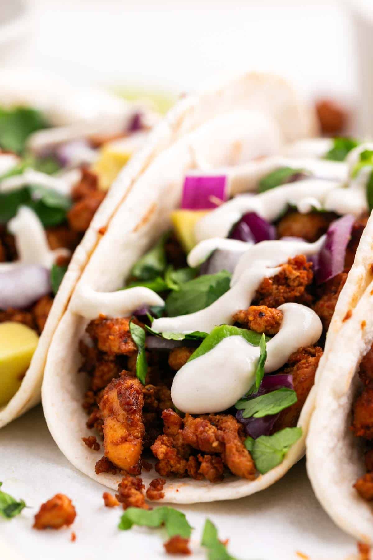 Homemade tofu tacos with avocado, red onion, cilantro, and vegan sour cream.