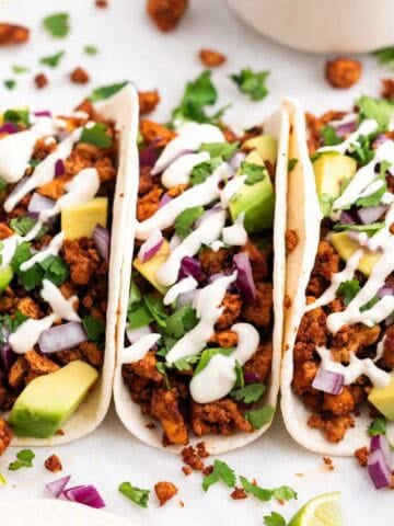 Homemade baked tofu tacos with fresh toppings and vegan sour cream.