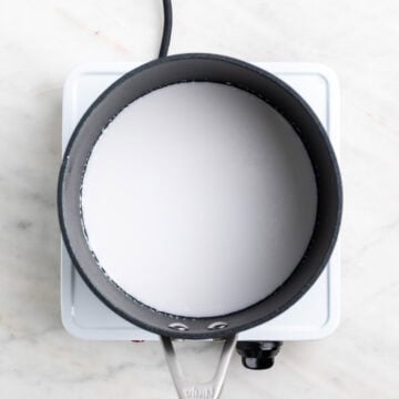 Hot coconut milk in a saucepan.