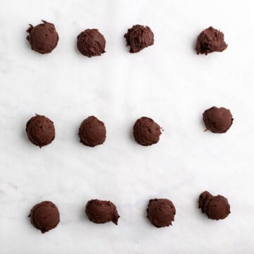 Scooped chocolate ganache on parchment paper.