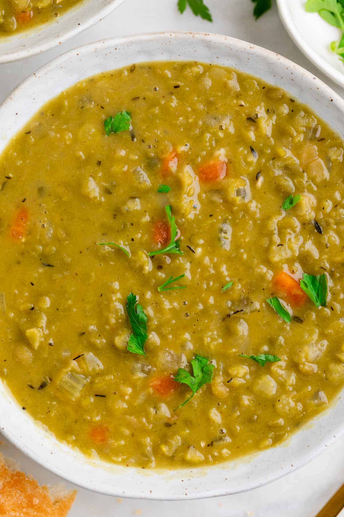 Bowl of vegan split pea soup topped with parsley.