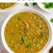 Vegan split pea soup served in two bowls with bread and parsley.