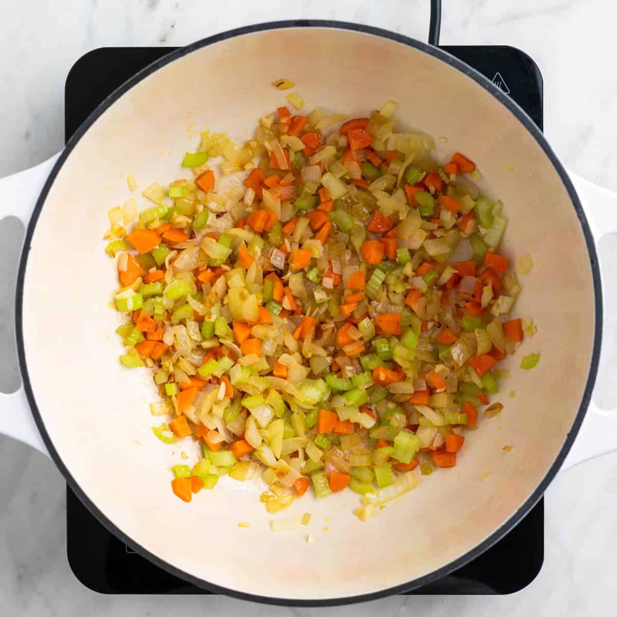 Sautéed vegetables cooking in a pot.