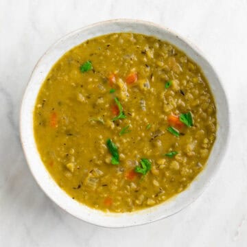 Vegan split pea soup in a bowl garnished with parsley.