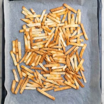 Crispy baked tortilla strips on a baking sheet.