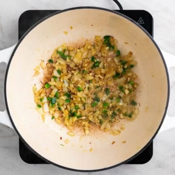 Onion, garlic, and jalapeño sautéing in a pot.