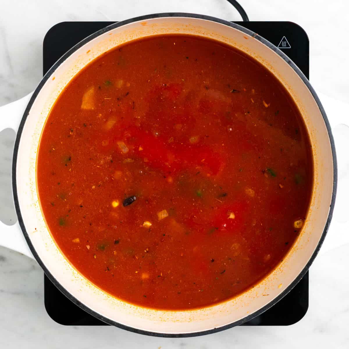 Cooked black bean tortilla soup in a large pot.