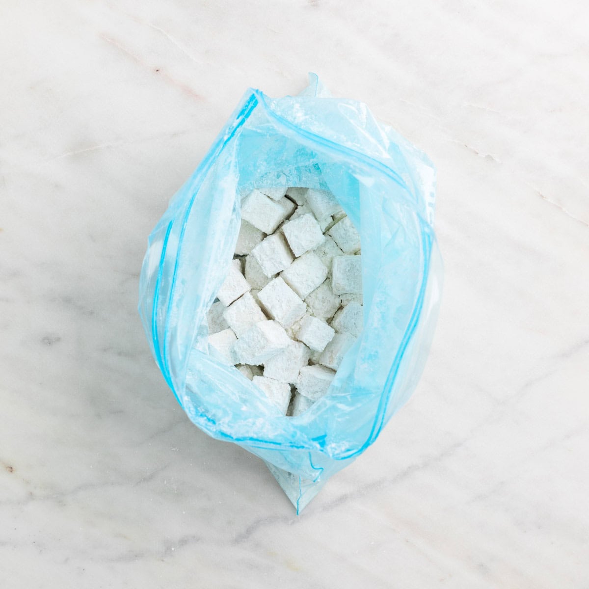 Tofu cubes coated with cornstarch and salt.