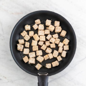 Tofu cooking in a pan.