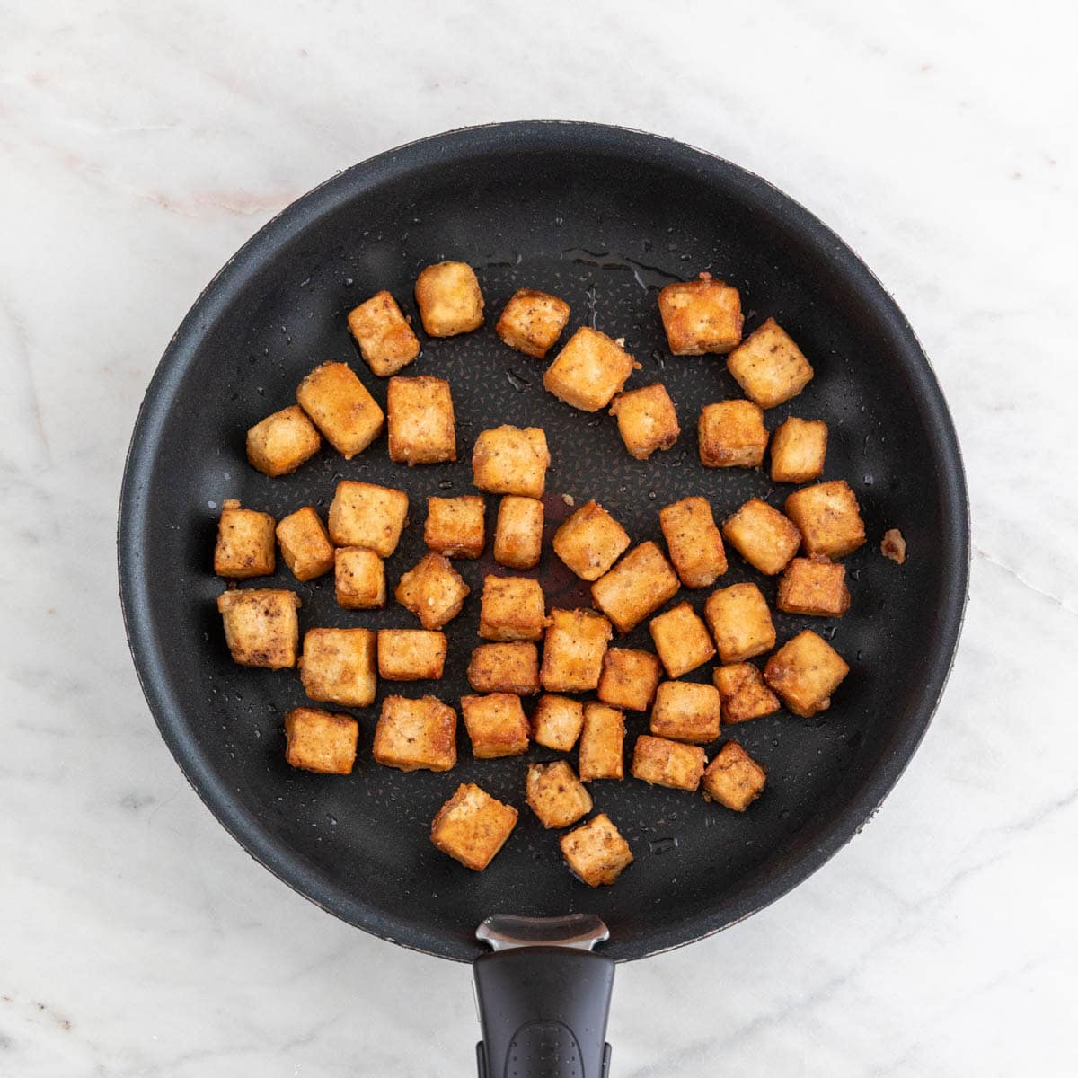 Crispy fried tofu in a pan.