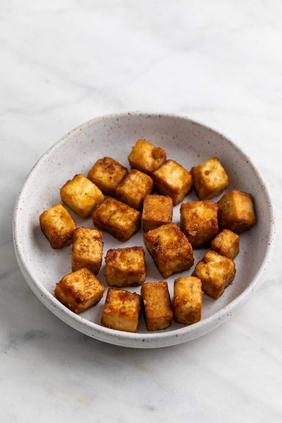 Golden crispy pan fried tofu cubes.