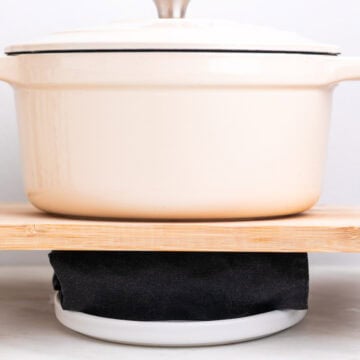 Close-up of tofu pressing with a towel and pot.