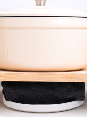 Close-up of tofu pressing with a towel and pot.