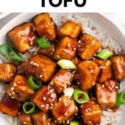 Mongolian tofu served over rice with scallions and sesame seeds on top.