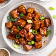 Mongolian tofu served over rice with scallions and sesame seeds.