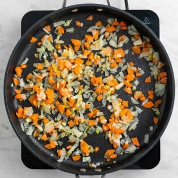 Garlic onion and carrot cooking in a pan.
