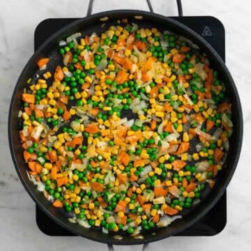 Peas and corn cooking with vegetables.