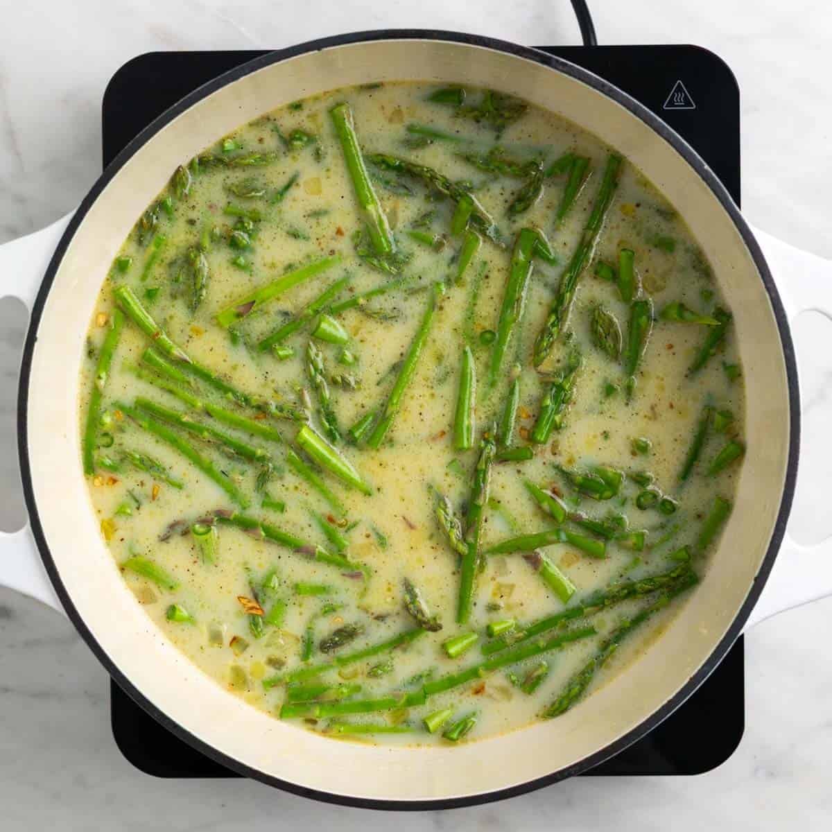 Asparagus potatoes and broth in the pot.