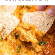 Scooping vegan buffalo chicken dip with a tortilla chip.