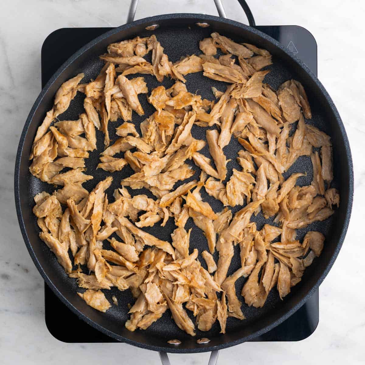 Saut&eacute;ed vegan chicken in a skillet.