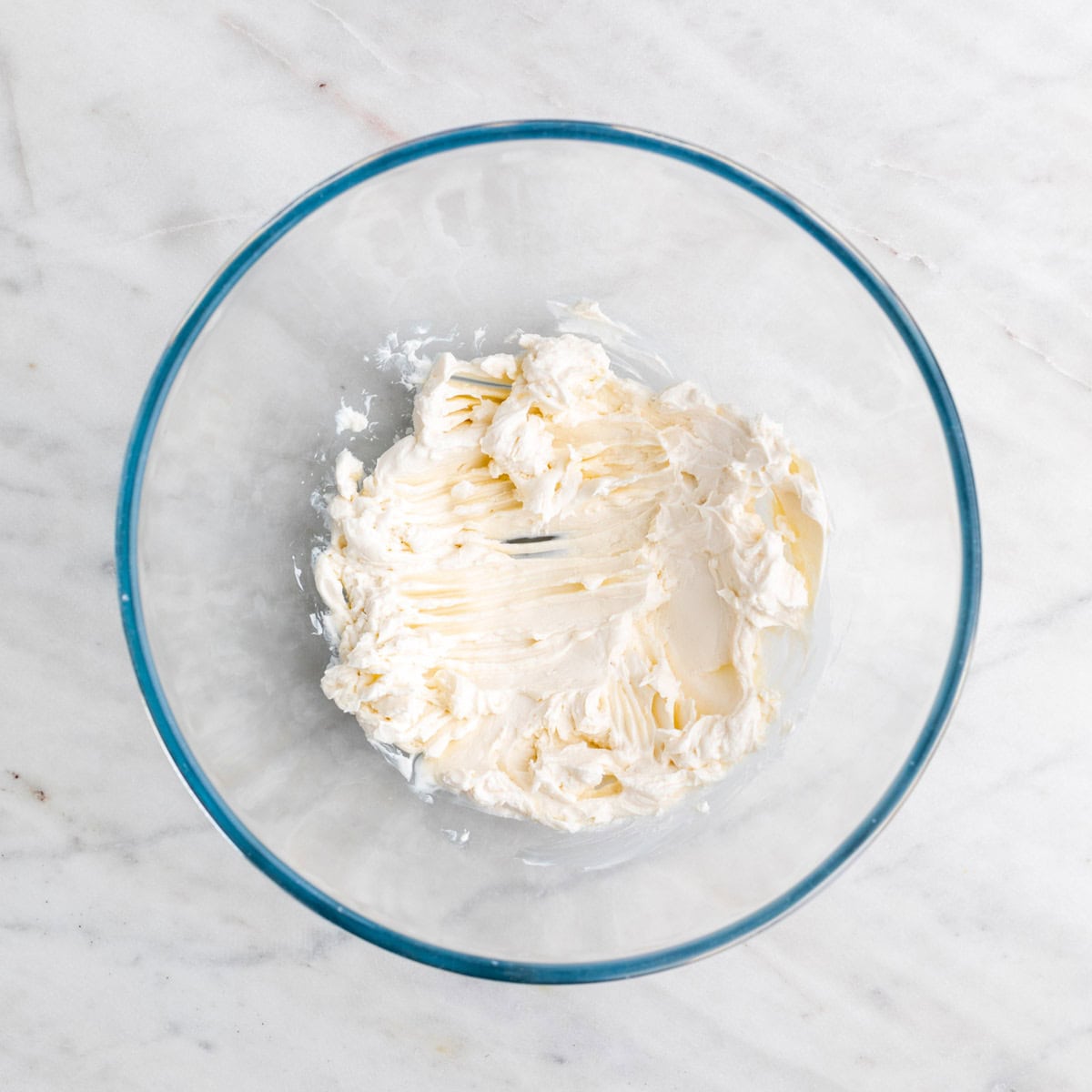 Mixing vegan cream cheese in a bowl.