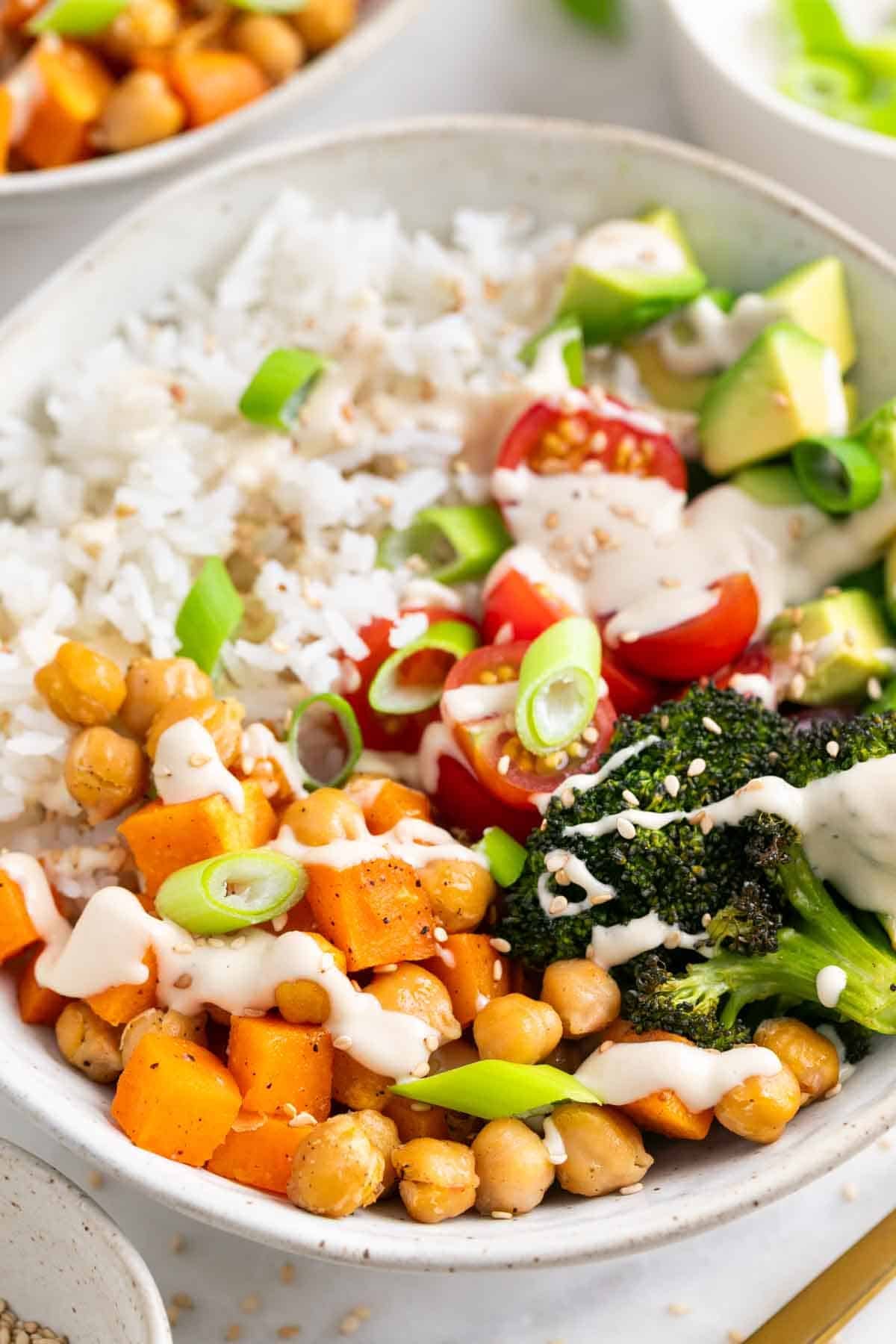 Vegan rice bowls with roasted vegetables and tahini dressing.