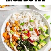 Vegan rice bowl served with a fork and sprinkled with sesame seeds.