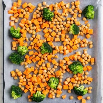 Sweet potato, broccoli, and chickpeas on a baking sheet before roasting.