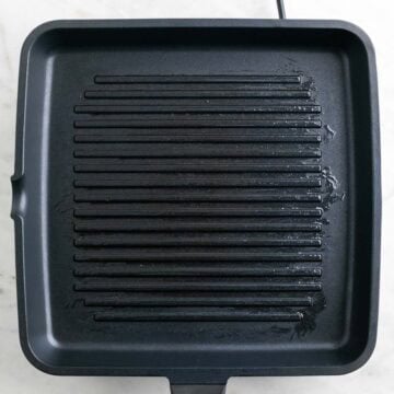Grill pan preheating on the stove with a light layer of oil.