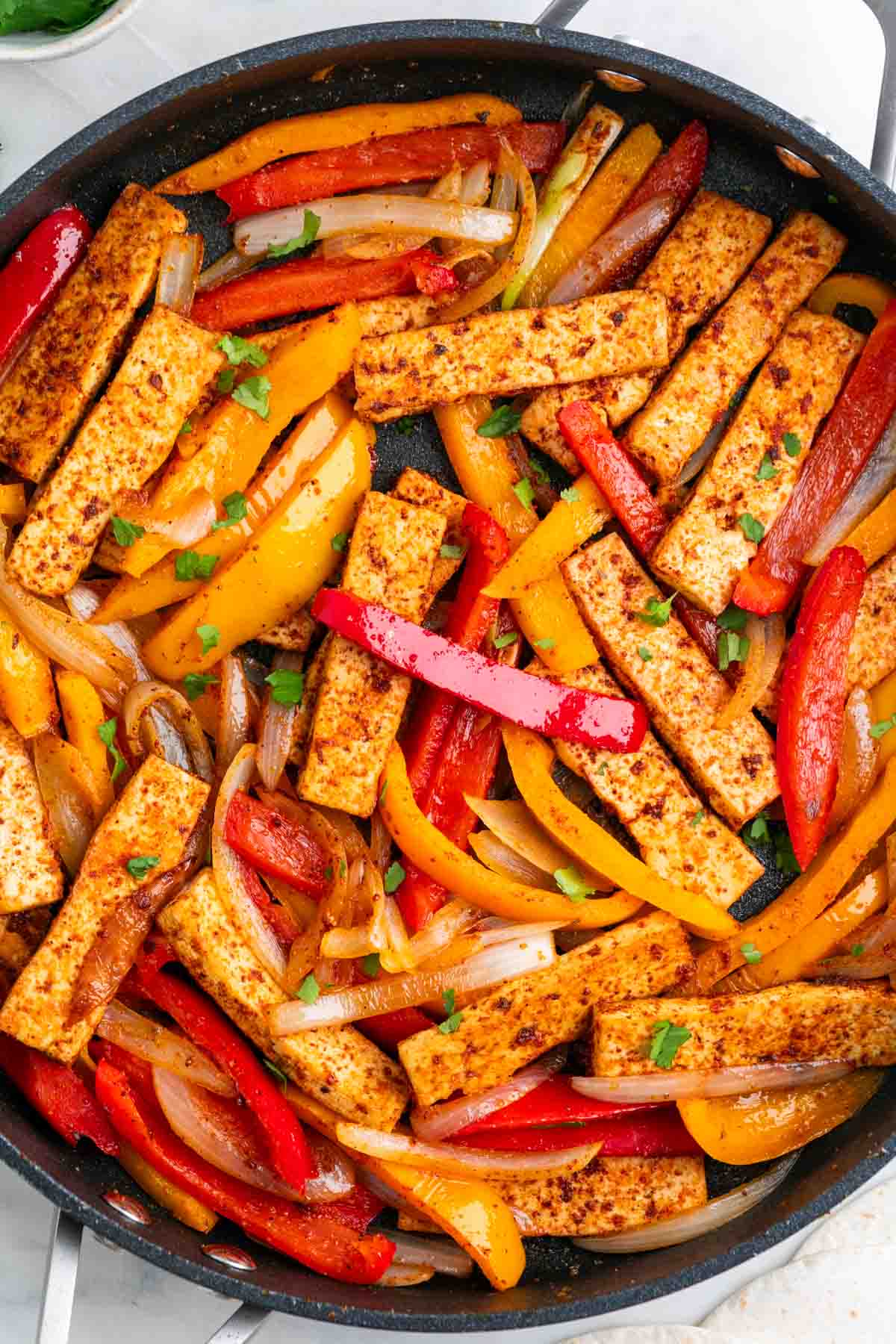 Skillet tofu fajitas with bell peppers and fresh cilantro on top