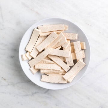 Tofu strips in a bowl before cooking