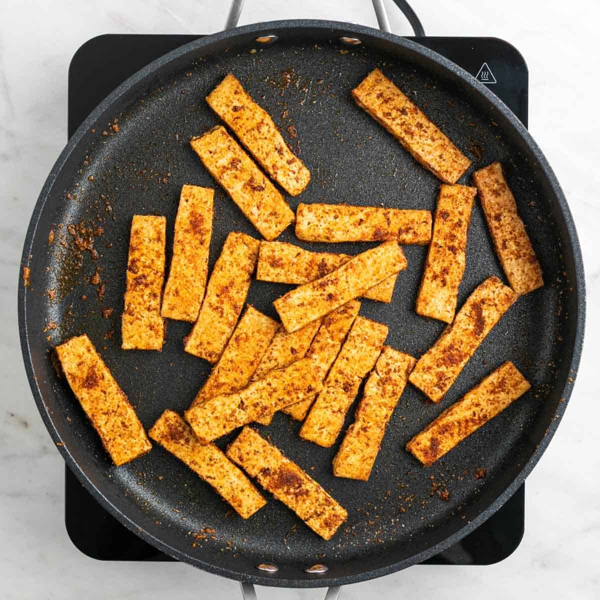 Tofu cooked with spices in a skillet
