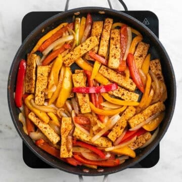 Tofu and vegetables cooking together in a skillet