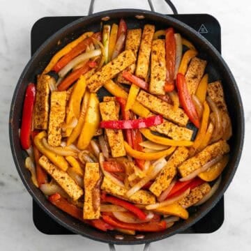 Tofu fajitas with vegetables and lime juice in a skillet