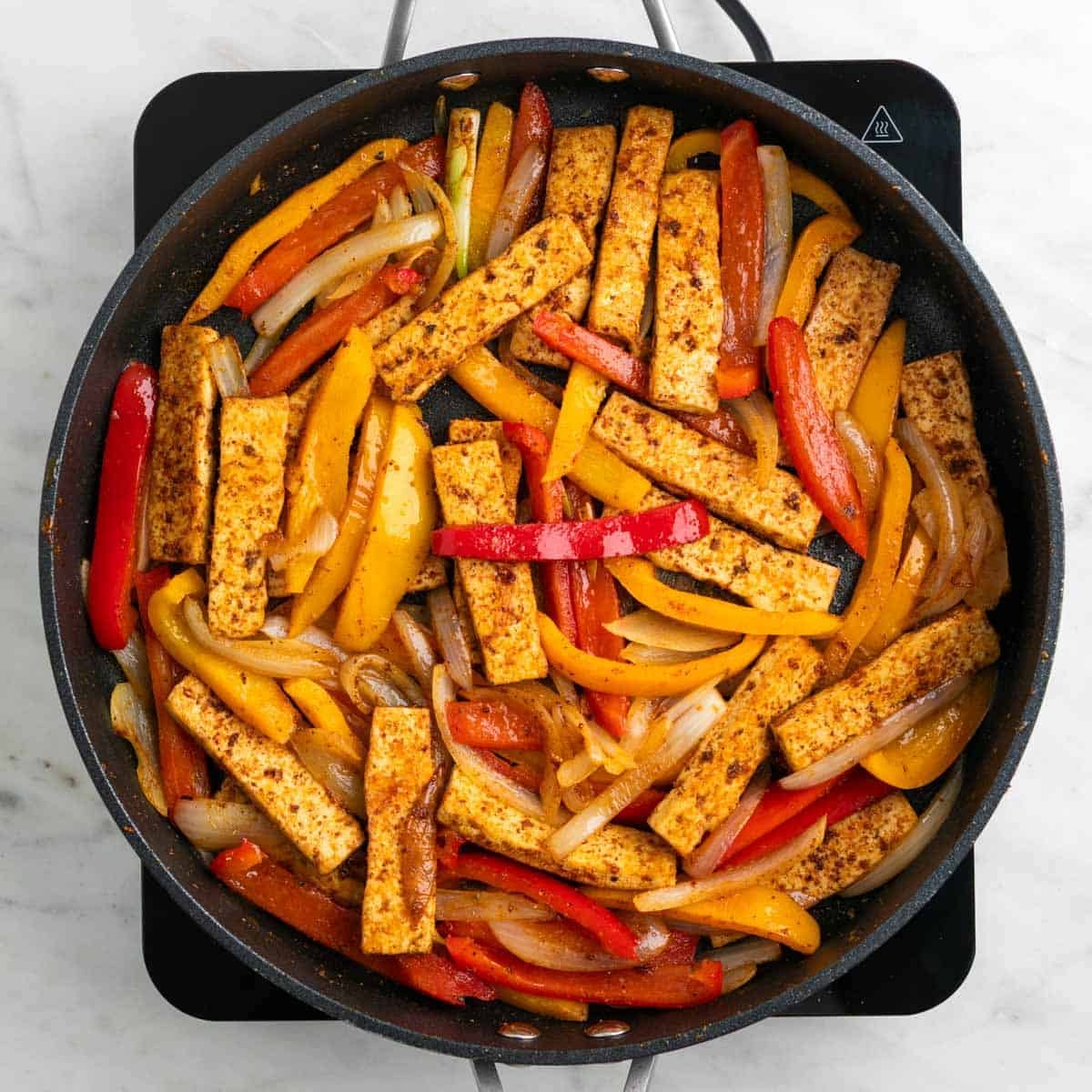 Tofu fajitas with vegetables and lime juice in a skillet
