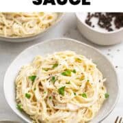 Creamy tofu pasta with spaghetti served on two plates with parsley and black pepper