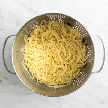 Cooked spaghetti draining in a colander