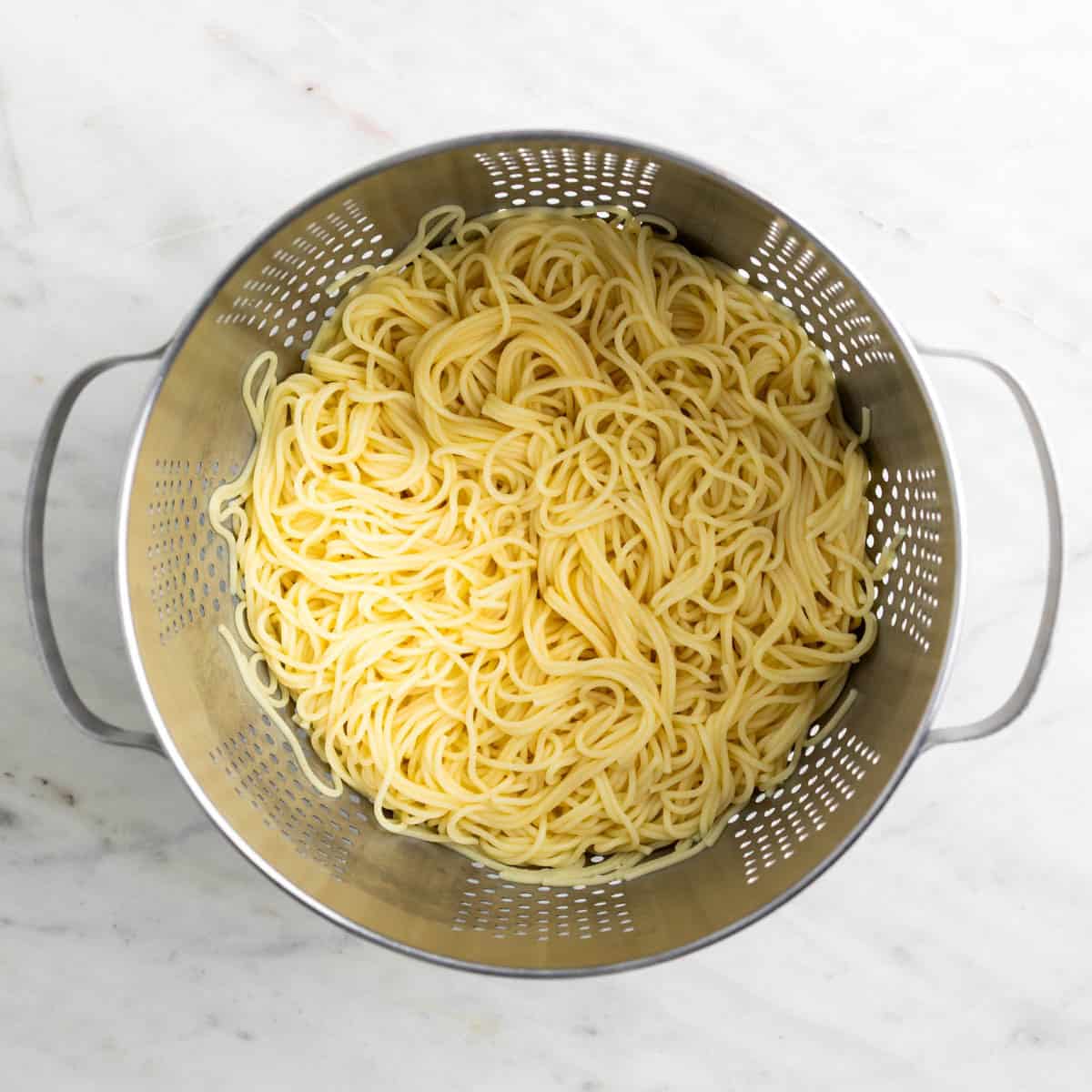 Cooked spaghetti draining in a colander