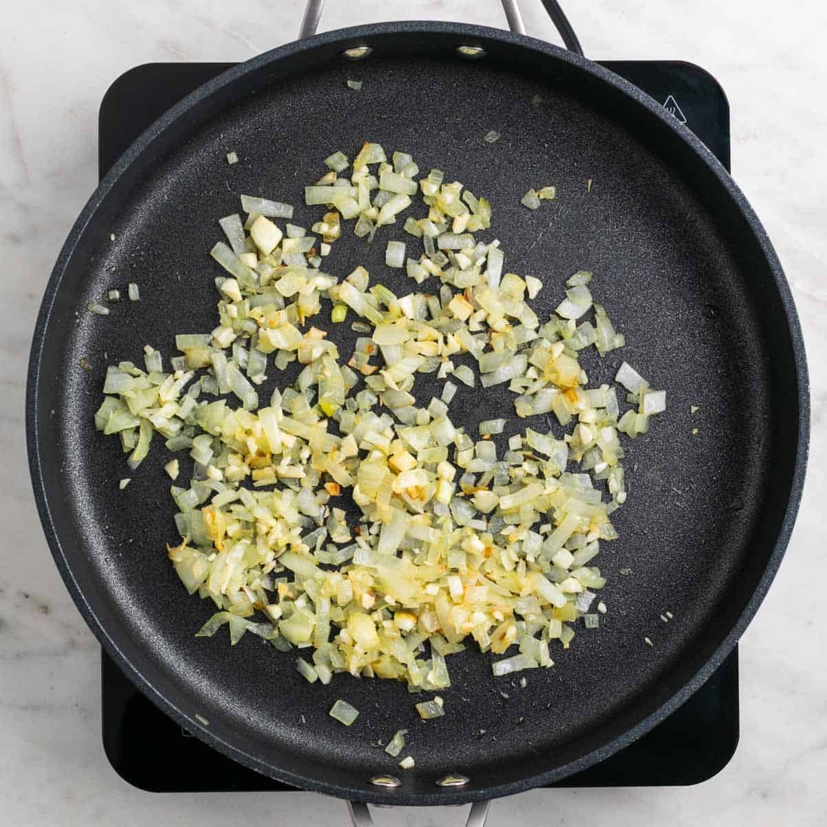 Onion and garlic cooking in a skillet