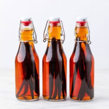 Glass bottles of homemade vanilla extract with vanilla beans after 3 months