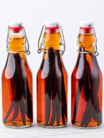 Glass bottles of homemade vanilla extract with vanilla beans after 3 months