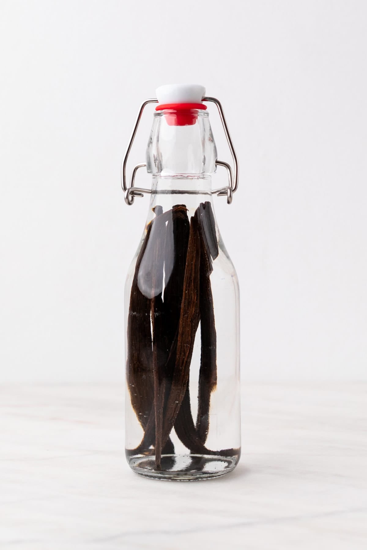 Glass bottle with vanilla beans fully covered in vodka