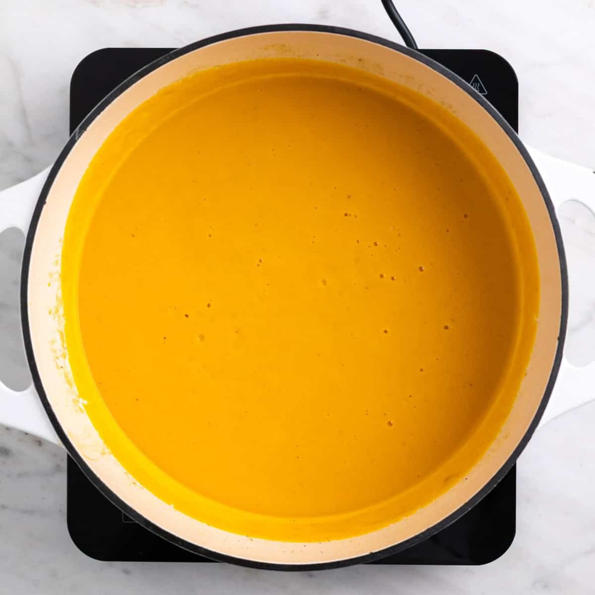 Blended vegan carrot soup in a pot, smooth and creamy