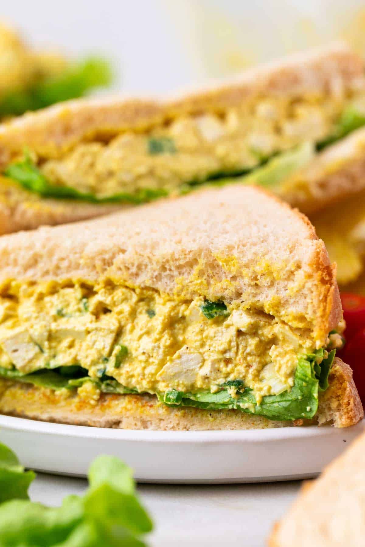 Two tofu egg salad sandwiches served on a plate